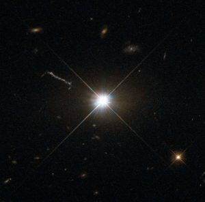 This image from Hubble’s Wide Field and Planetary Camera 2 (WFPC2) is likely the best of ancient and brilliant quasar 3C 273, which resides in a giant elliptical galaxy in the constellation of Virgo (The Virgin). Its light has taken some 2.5 billion years to reach us. Despite this great distance, it is still one of the closest quasars to our home. It was the first quasar ever to be identified, and was discovered in the early 1960s by astronomer Allan Sandage. The term quasar is an abbreviation of the phrase “quasi-stellar radio source”, as they appear to be star-like on the sky. In fact, quasars are the intensely powerful centres of distant, active galaxies, powered by a huge disc of particles surrounding a supermassive black hole. As material from this disc falls inwards, some quasars — including 3C 273  — have been observed to fire off super-fast jets into the surrounding space. In this picture, one of these jets appears as a cloudy streak, measuring some 200 000 light-years in length. Quasars are capable of emitting hundreds or even thousands of times the entire energy output of our galaxy, making them some of the most luminous and energetic objects in the entire Universe. Of these very bright objects, 3C 273 is the brightest in our skies. If it was located 30 light-years from our own planet — roughly seven times the distance between Earth and Proxima Centauri, the nearest star to us after the Sun — it would still appear as bright as the Sun in the sky.   WFPC2 was installed on Hubble during shuttle mission STS-125. It is the size of a small piano and was capable of seeing images in the visible, near-ultraviolet, and near-infrared parts of the spectrum.